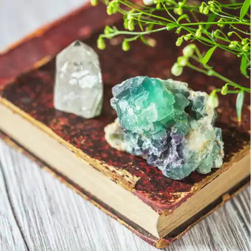 Two rough and polished mineral specimens on an antique book.